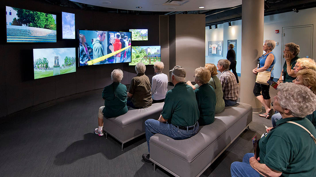 Audience watches six-monitor video program in a museum.